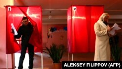 A man holds his ballot paper as he leaves a booth at a polling station in Donetsk, in the Kremlin-backed region of eastern Ukraine on November 11, 2018.