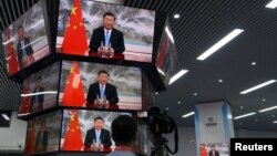 上海举行的中国国际进出口展销会媒体中心的多面电视屏幕播放中国领导人习近平的讲话。(2021年11月4日)