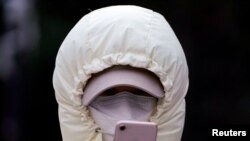 中国上海,一名戴口罩的女子在看手机(2020年1月29日)。