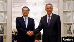 新加坡总理李显龙在新加坡总统府与中国总理李克强握手。(2018年11月12日)