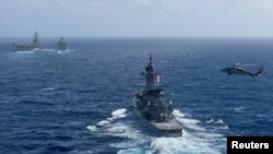 Một chiếc trực thăng hải quân Mỹ MH-60S Sea Hawk bay cạnh tài của lực lượng phòng vệ hàng hải Nhật Bản JS Shimakaze trong chuyến bổ xung hàng hải ngoài khơi bán đảo Triều Tiên.