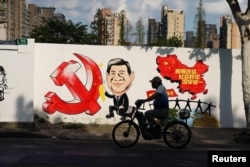 2018年9月28日,上海一条街上的宣传画,包括习近平的漫画形象、中共党徽和中国地图,还有文字“民族团结,社会稳定,国家统一”