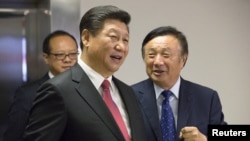 华为创始人任正非(右)陪同中国国家主席习近平参观华为在英国伦敦的办公室。(2015年10月21日)