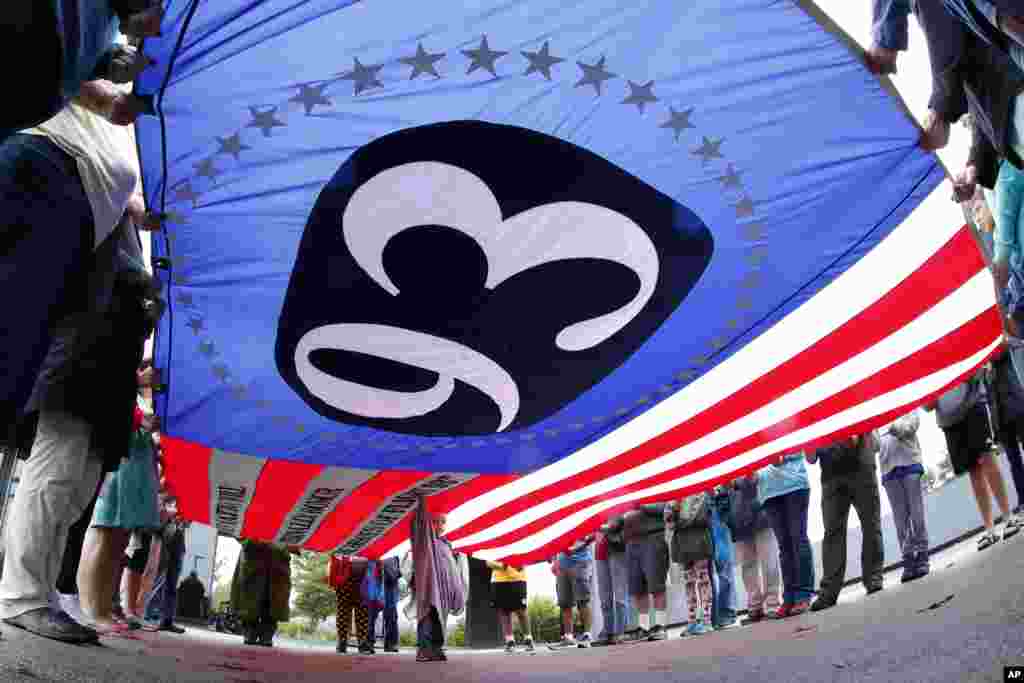 美国宾夕法尼亚州尚克斯维尔的国家纪念场,参观者举着一面巨大的旗帜,上面有“93”字样,纪念当年93号航班上的英烈。