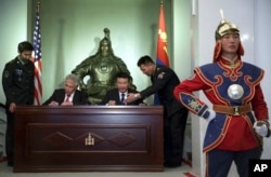 美国国防部长哈格尔与蒙古国防部长巴特额尔德尼在蒙古国防部参加签署联合声明的仪式。(2014年4月10日)