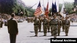 资料照片:时任美国总统乔治·H·W·布什在华盛顿问候“沙漠风暴凯旋游行”的领队H·诺曼·施瓦茨科夫将军。(1991年6月8日)