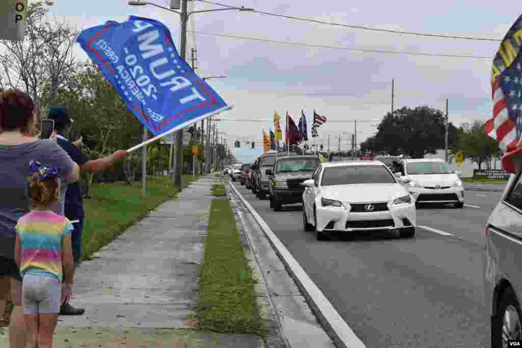 Ông Nguyễn Văn Thành, 55 tuổi, vẫy cờ ủng hộ Tổng thống Trump tại một góc đường để cổ động đoàn xe đi ngang qua. Cư dân thành phố St. Petersburg này cho biết ông không bỏ biếu cho ông Trump trong cuộc bầu cử tổng thống năm 2016 vì nghĩ rằng doanh nhân dẫn chương trình truyền hình thực tế này “muốn danh vọng.” Bây giờ ông là một trong những người ủng hộ ông Trump nhiệt thành nhất và thường xuyên tham dự những sự kiện như thế này trong cộng đồng người Việt và với những người bạn Mỹ khác. “Vị tổng thống này nói là ông làm chứ không phải không làm và thứ hai là chưa có một vị tổng thống nào có một thái độ rõ ràng với những thể chế độc tài như ông Trump,” ông Thành giải thích.