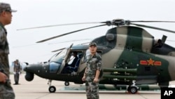 中国士兵守卫在一架武直-9旁边。(2012资料照)