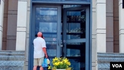 一名外国游客正在参观“杀人场”的骷髅塔。(美国之音朱诺拍摄,2013年5月30日)