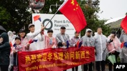 资料照片:中国国务院总理李强访问位于奥克兰阿尔伯特山的新西兰植物与食品研究所时支持者聚集在道路上。(2024年6月14日)