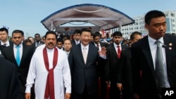 中国国家主席习近平和斯里兰卡当时的总统拉贾帕克萨2014年参加斯里兰卡科伦坡港口城建设的启动仪式,这个建设项目资金大部分由中国贷款。(资料照)