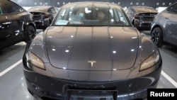 在北京的特斯拉的交付中心,顾客坐在一辆特斯拉Model Y电动汽车内。(2025年1月8日)