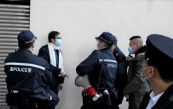 大批警员包围民阵副召集人叶锦龙,一度指控民阵2021元旦日车巡活动违反限聚令, 最后登记叶锦龙身分证资料后放行,没有发出任何告票 (美国之音/汤惠芸)