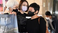 香港电台编导蔡玉玲(右)因报道7-21元朗袭击事件,被控作出两项虚假陈述罪, 案件3月24日正式开审,她进入法庭应讯前向支持者致谢 (美国之音/汤惠芸)