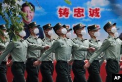 中国武警士兵列队走过宣传习近平领导的宣传画。(2020年5月25日)