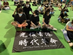 参与六四31周年维园烛光集会的年轻人展示反送中运动旗帜(美国之音/汤惠芸)