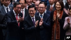 资料照片: 2024年3月19日香港立法会通过《基本法》第 23 条立法后,香港行政长官李家超鼓掌。