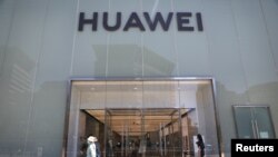 人们走过北京街头的华为专卖店。 (2021年6月3日)