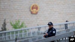 资料照:一名警察在北京审理维权律师许志永案的中国最高人民法院外巡逻。(2014年4月11日)