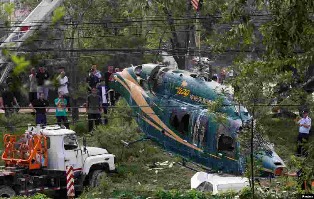 2018年7月30日，北京，一架起重机吊起一架坠落的直升机。直升机坠落在朝阳区奶子房村奶东休闲广场东侧，据悉除了驾驶员受了轻伤之外没有人员伤亡。&nbsp;