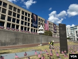 在劳工节长周末到来前,工人在位于华盛顿的美国劳工部总部大楼附近插放小美国国旗。(2025年8月28日)