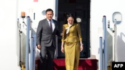 柬埔寨首相洪马内(左)抵达北京首都国际机场,出席2023年10月16日在北京举行的第三届“一带一路”高峰论坛。(法新社照片)