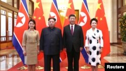 中国国家主席习近平和夫人彭丽媛在北京人大会堂同朝鲜国务委员会委员长金正恩和夫人李雪主合影。(2018年3月28日)