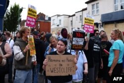 2024年8月7日同情移民的示威者聚集在英格兰东部滨海绍森德附近韦斯特克利夫的移民律师办公室外,反对极右派人士发起的反移民抗议活动