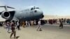 美国空军C-7运输机在喀布尔国际机场起飞时上百人在跑道上跟随奔跑。（2021年8月16日）