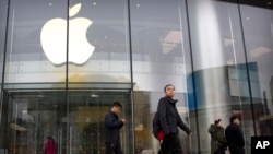 2019年2月26日,行人路过北京一条户外购物街的苹果专卖店。(美联社照片)