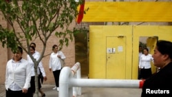 资料照片:新疆喀什的维吾尔族妇女离开一个进行政治学习的中心。(2018年9月6日)