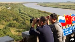 在中国吉林省延边地区,在中朝边界附近的一个观察站,一名男子用望远镜张望。(2017年9月9日)