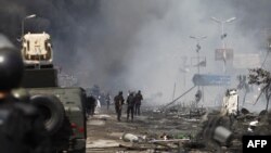 埃及安全部队驱散开罗阿巴•拉达维亚抗议营地的示威人群后站在废墟中间。(2013年8月14日)