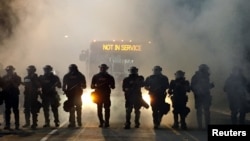FILE - Police officers wearing riot gear block a road during protests after police fatally shot Keith Lamont Scott in the parking lot of an apartment complex in Charlotte, North Carolina, Sept. 20, 2016. 