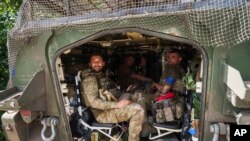 在靠近乌俄边界的乌克兰苏梅州，从俄罗斯库尔斯克州返回的乌克兰军人坐在一辆装甲车内。(2024年8月14日)