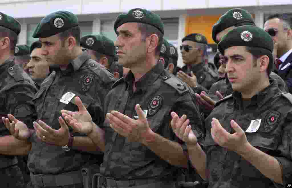 Turkish police officers pray during a ceremony at the police headquarters in Ankara for special operations officer Sahin Polat Aydin, one of the four officers killed Monday in a landmine attack attributed to militants of the Kurdistan Workers' Party, or PKK, in Silopi, southeastern Turkey, Aug. 11, 2015.