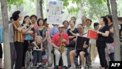 资料照:一组退休人员在北京公园里唱红歌。