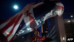 在2020年6月20日奥克拉荷马州的塔尔萨市造势活动的前夜，特朗普总统的支持者在高呼“美国”。