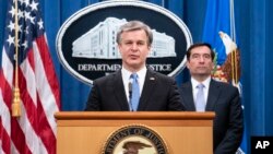 联邦调查局局长克里斯托弗·雷在司法部举行的网络新闻发布会上讲话,司法部助理部长约翰·德默斯站在一旁。(2020年10月28日)