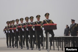 中国仪仗队在辽宁省沈阳市的一个机场抱着由韩国归还的装有中国军人遗骸的盒子。那些死者在1950年至1953年的朝鲜战争中丧生。(2016年3月31日)