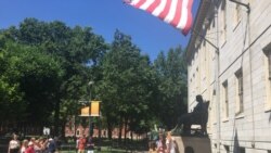 资料照片:游人与哈佛大学的约翰·哈佛铜像合影。