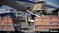 希腊雅典国际机场的工人从国航飞机上卸下装有中国政府捐赠的抗疫医疗用品。(2020年3月21日)