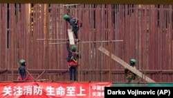 在塞尔维亚贝尔格莱德以北50公里的塞尔维亚北部城镇兹雷尼亚宁附近,越南工人在一家中国汽车轮胎工厂建筑工地工作。(2021年11月18日)