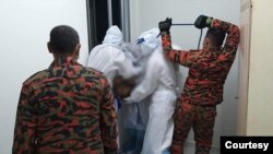 ၂၀၂၀ ခုနှစ်၊ ဇွန်လ ၁၈ ရက်နေ့ ညက ကြိုးဆွဲချ သေဆုံးသူမြန်မာလူငယ်ကို မလေးအာဏာပိုင်တွေနဲ့ မြန်မာလူမူကူညီရေးအဖွဲ့က သယ်ဆောင်နေတဲ့ မြင်ကွင်း။ (ဇွန် ၁၈၊ ၂၀၂၀)