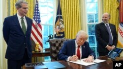 在白宫椭圆形办公室,特朗普总统在财政部长贝森特和被提名为商务部长的卢特尼克的陪同下,签署一项行政命令。(2025年2月3日)