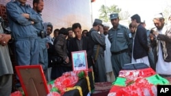 4月28日阿富汗人站在两名加兹尼省被路边炸弹杀害的两名警方人员的灵柩旁