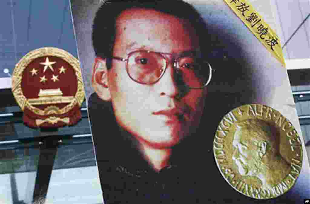 在颁奖典礼的第二天， 香港民主派市民前往中国驻香港联络办公室大楼前示威，敦促中国政府释放刘晓波，人们举着刘晓波及其奖牌的照片（2010年10月11日）