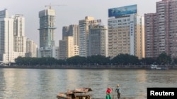 资料照:2013年12月7日,广东省广州市,一对夫妇沿着珠江(或珠江)附近的办公楼钓鱼。(路透社)