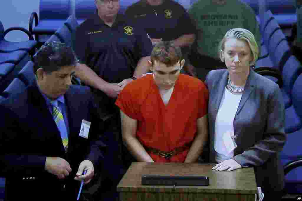 A video monitor shows school shooting suspect Nikolas Cruz (C) making an appearance before Judge Kim Theresa Mollica in Broward County Court, Thursday, Feb. 15, 2018, in Fort Lauderdale, Fla.