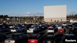 在美国科罗拉多州德尔塔市,人们坐在自己的车里举行了免下车复活节仪式。(2020年4月12日)